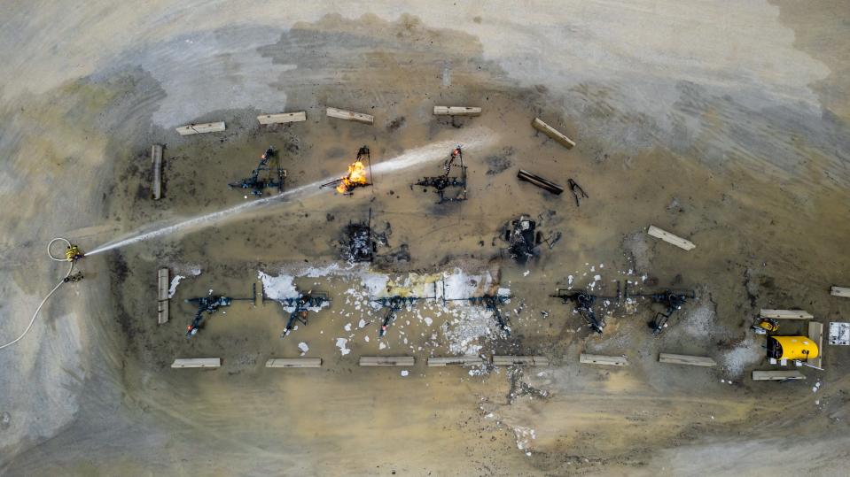 Firefighters work to control an oil well head fire at the CHK Jamar Pad owned and maintained by Encino Energy, Tuesday, April 4 in North Township, Harrison County. The fire was called in early Tuesday morning.