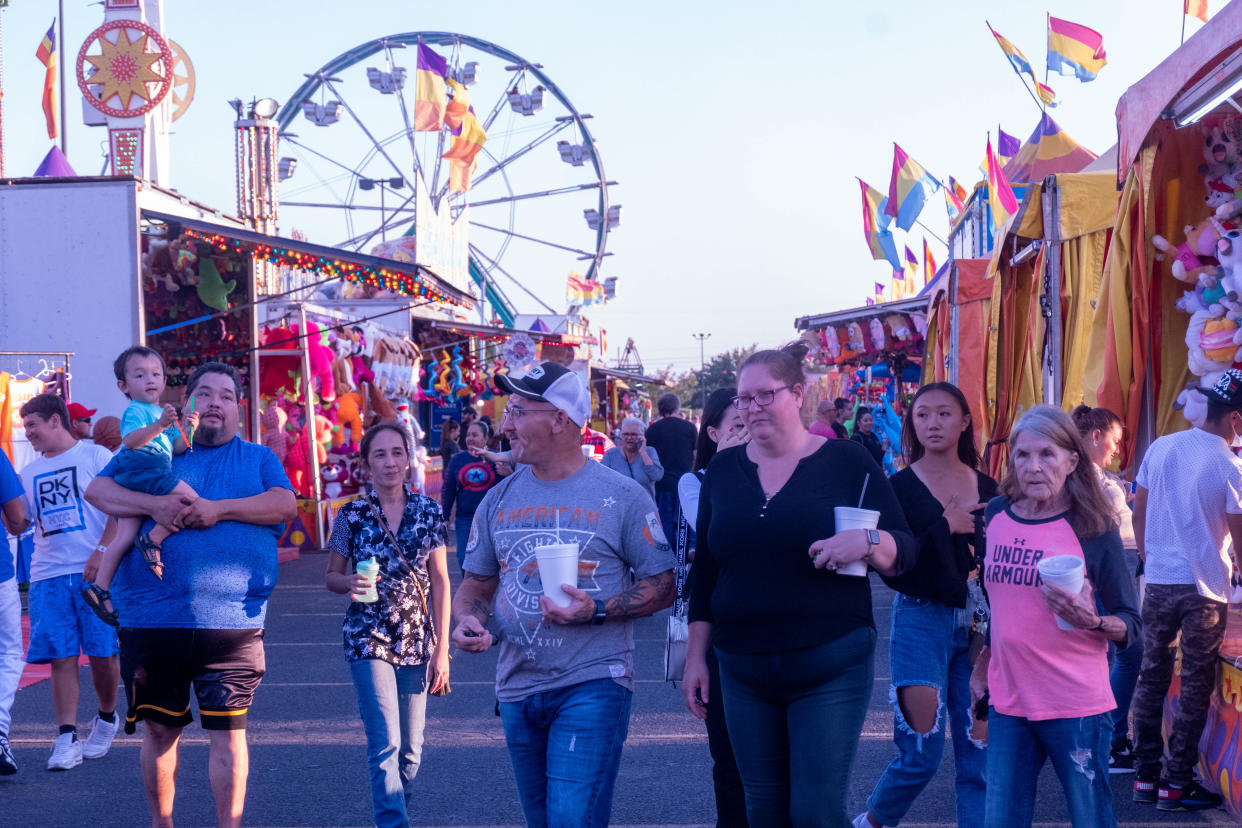 Fair patrons walk among the midway at the Tri-State Fair Sept. 20, 2021.