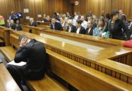 Oscar Pistorius blocks his ears inside the high court on the second day of his trial in Pretoria, South Africa, Tuesday, March 4, 2014. Pistorius is charged with murder for the shooting death of his girlfriend, Reeva Steenkamp, on Valentines Day in 2013. (AP Photo/Kim Ludbrook, Pool)