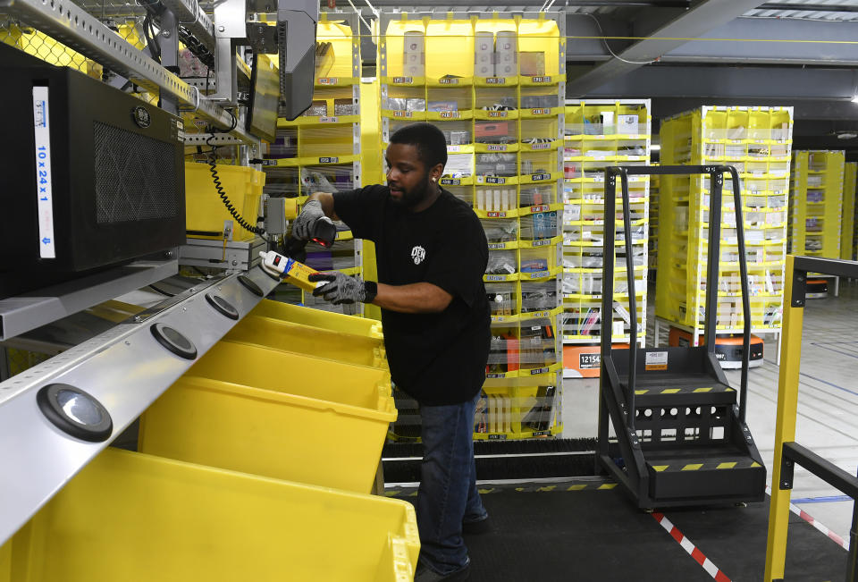 THORNTON, CO - FEBRUARY 19:  Mike May pulls items out of pods to be delivered to customers at Amazon's Fulfillment Center on March 19, 2019 in Thornton, Colorado. The facility which opened in July of 2018 is 855,000 square feet, and employees over 1500 people. The Thornton facility is a state-of-the-art facility that uses Amazon Robotics to move the merchandise around from one area to the next.  Hundreds of workers perform a variety of jobs in the huge facility. Many workers stand at stations, picking items to ship from trays brought to them by robots that roam the massive warehouse floor. The robotic facility, near I-25 and 144th Avenue, distributes small- and medium-sized items and  allows for quicker delivery of orders in the metro area.  (Photo by Helen H. Richardson/MediaNews Group/The Denver Post via Getty Images)