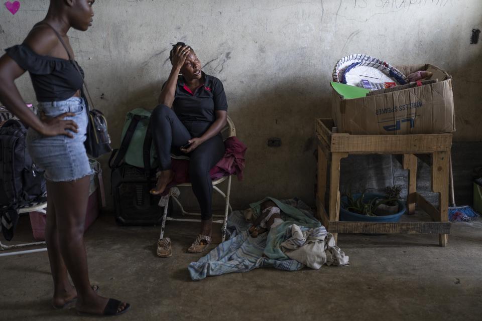 FILE - Elise Mesadieu cries as she sits next to the body of her 1-year-old goddaughter, who is believed to have died of dehydration due to cholera, at a shelter for people displaced by gang violence, in Port-au-Prince, Haiti, May 30, 2023. (AP Photo/Ariana Cubillos, File)