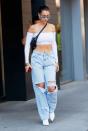 <p>In a white, off-the-shoulder crop top and ripped jeans in NYC.</p>