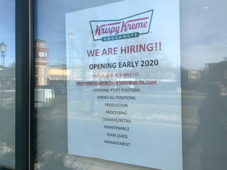 The Krispy Kreme in East Rutherford has a "now hiring" poster on the window.