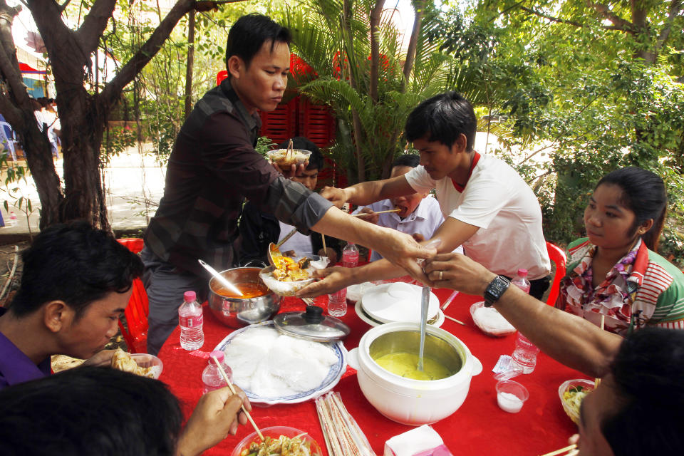 Cambodian garment workers eat noodle as their breakfast at a Buddhist pagoda at outside Phnom Penh, Cambodia, Sunday, June 9, 2019. The bitter decadeslong rivalry between Hun Sen, Cambodia's strongman leader, and Sam Rainsy, the self-exiled chief political rival and critic, has sometimes played out in deadly violence. But on Sunday, soup rather than blood was likely to be spilled. (AP Photo/Heng Sinith)