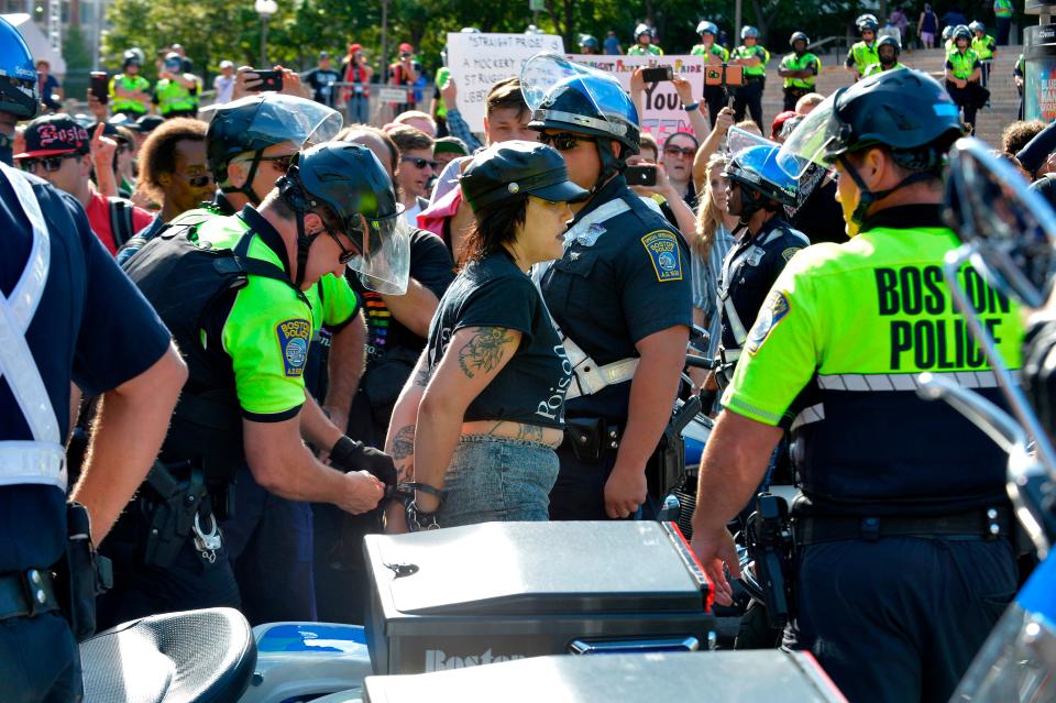 Boston Police officers arrest an anti-parade demonstrator during the 