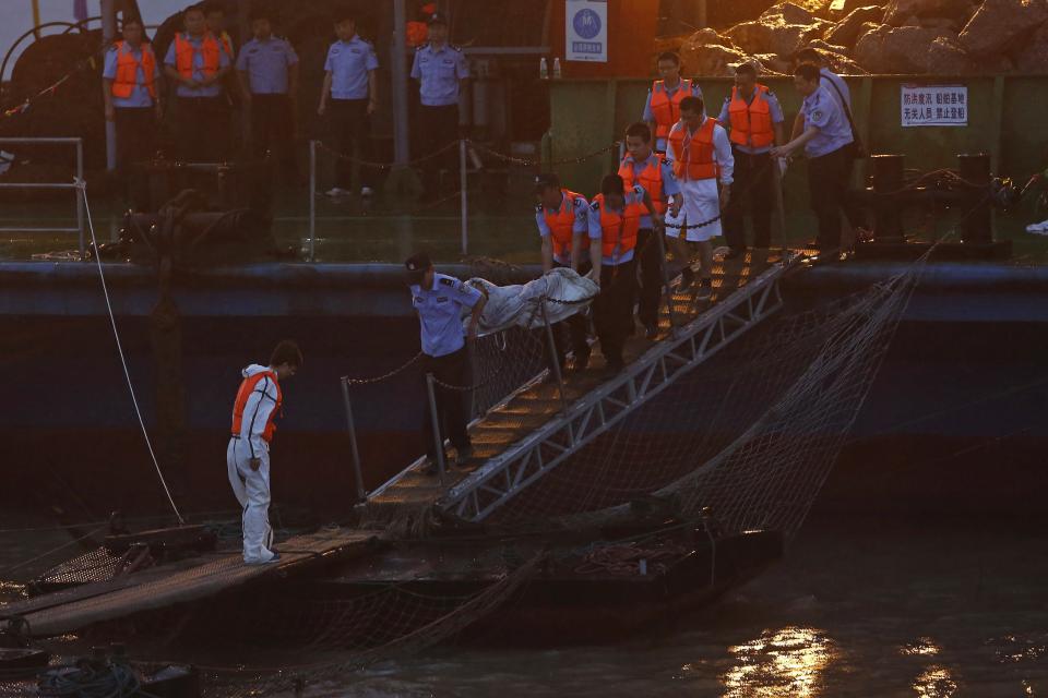 Rescue workers carry a body from the sunken ship in the Jianli section of Yangtze River