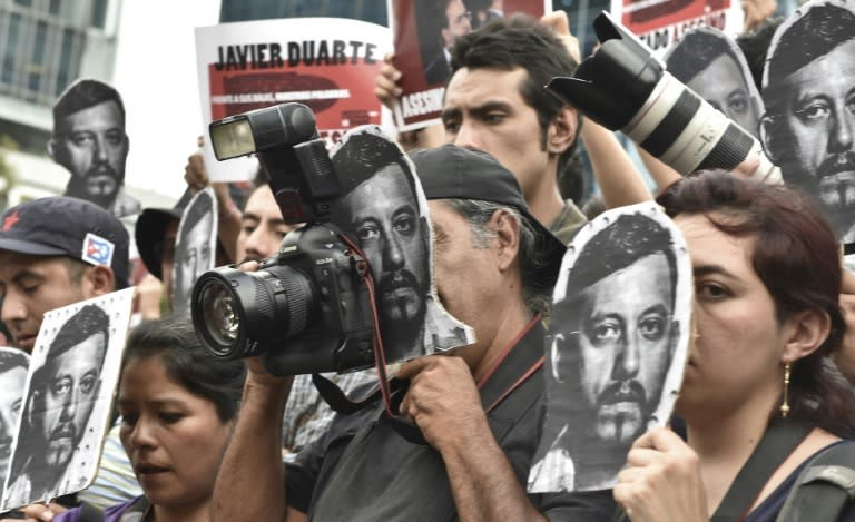 Mexican photojournalists hold pictures of their murdered colleague Ruben Espinosa during a demonstration held at the Angel of Independence square in Mexico City, on August 2, 2015