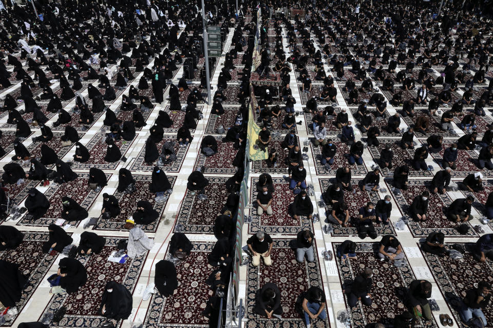 Men, on right, and women on left, mourn during an annual ceremony commemorating Ashoura, the anniversary of the 7th century death of Imam Hussein, a grandson of Prophet Muhammad, and one of Shiite Islam's most beloved saints, who was killed in a battle in Karbala in present-day Iraq, at the courtyard of the Saint Abdulazim shrine in Shahr-e-Ray, south of Tehran, Iran, Sunday, Aug. 30, 2020. In Iran, which has the largest number of deaths from the coronavirus in the region, authorities allowed limited mourning rituals, urged social distancing and made wearing masks mandatory. (AP Photo/Vahid Salemi)