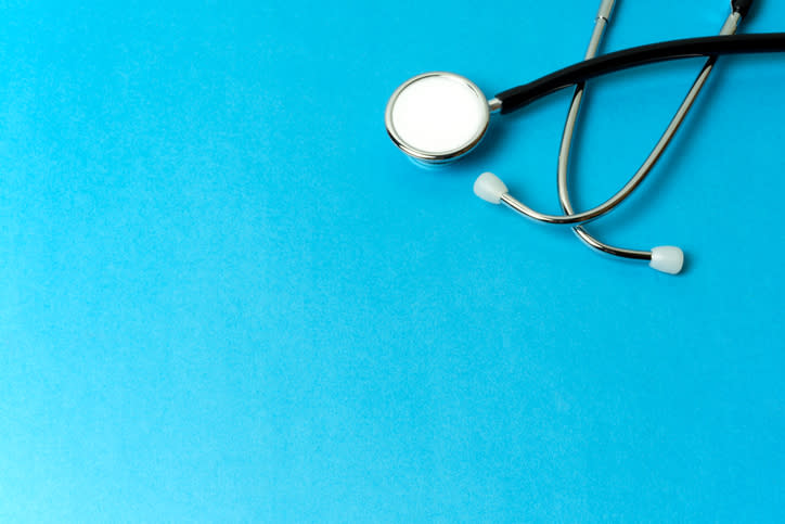 A stethoscope sitting on a blue background.