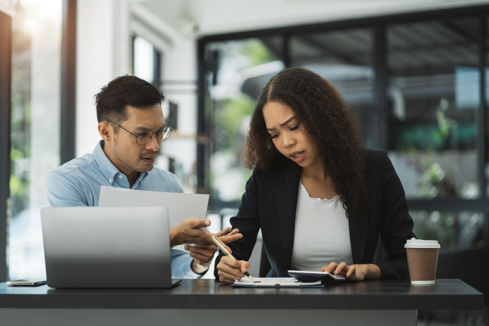 two people discussing documents at work