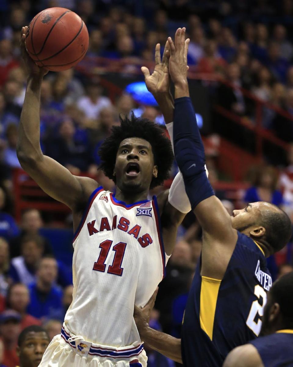 Kansas guard Josh Jackson (11) shoots while covered by West Virginia guard Jevon Carter (2) during the first half of an NCAA college basketball game in Lawrence, Kan., Monday, Feb. 13, 2017. (AP Photo/Orlin Wagner)