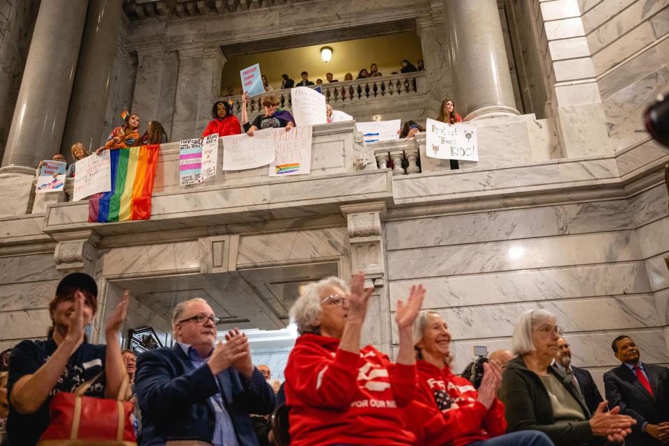 Supporters of the bill clap during a press conference while those opposed to the bill carry signs on the floor above at the Kentucky state Capitol in Frankfort, Ky., on Wednesday, March 29.