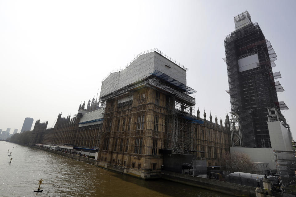 FILE - Britain's Houses of Parliament, covered in hoarding and scaffolding as it undergoes restoration work to repair the crumbling building, in London, Wednesday, April 17, 2019. British lawmakers are warning that the country's Parliament building is at “real and rising” risk of destruction. The House of Commons Public Accounts Committee said Parliament is “leaking, dropping masonry and at constant risk of fire,” as well as riddled with asbestos. The committee said Wednesday, May 17, 2023 that “there is a real and rising risk that a catastrophic event will destroy” the building before long-delayed restoration work is done. (AP Photo/Kirsty Wigglesworth, File)