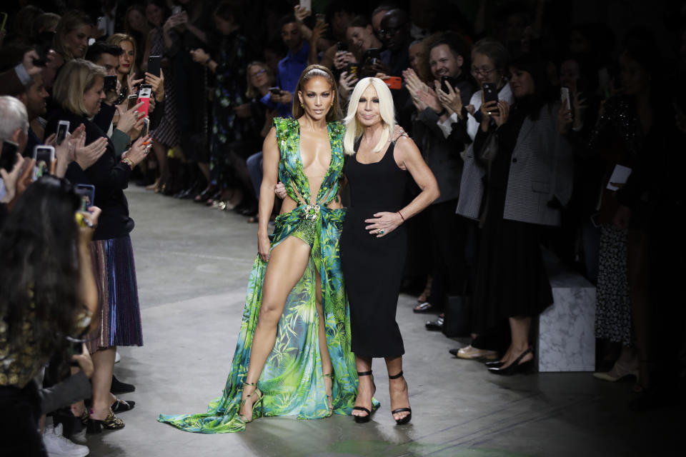 Actress Jennifer Lopez, left, and designer Donatella Versace accept applause at the conclusion of the Versace Spring-Summer 2020 collection, unveiled during the fashion week, in Milan, Italy, Friday, Sept. 20, 2019. (AP Photo/Luca Bruno)