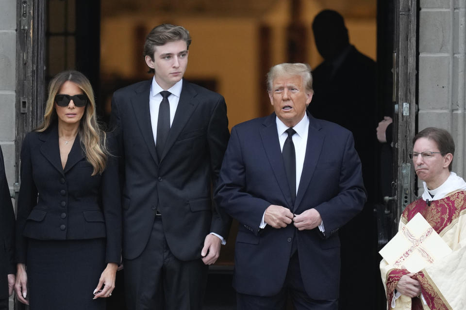 Former President Donald Trump, center right, stands with his wife Melania, left, and their son Barron, center left, outside the Church of Bethesda-by-the-Sea at the start of a funeral for Amalija Knavs, the former first lady's mother, in Palm Beach, Fla., Thursday, Jan. 18, 2024. (AP Photo/Rebecca Blackwell)