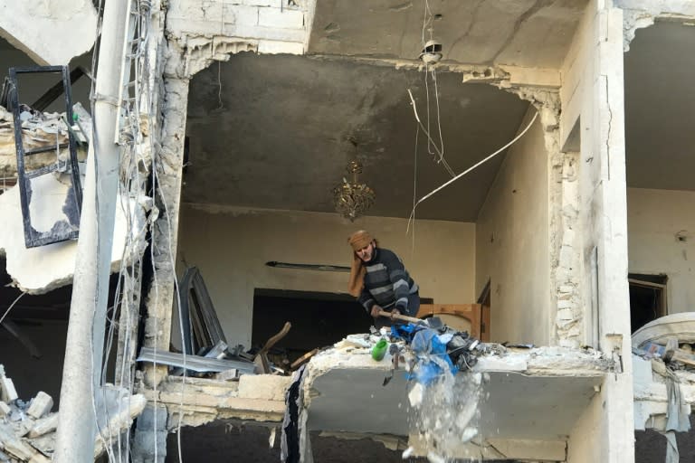 A man cleans debris in the aftermath of an explosion at a base for Asian jihadists in a rebel-held area of the northwestern Syrian city of Idlib on January 8, 2018