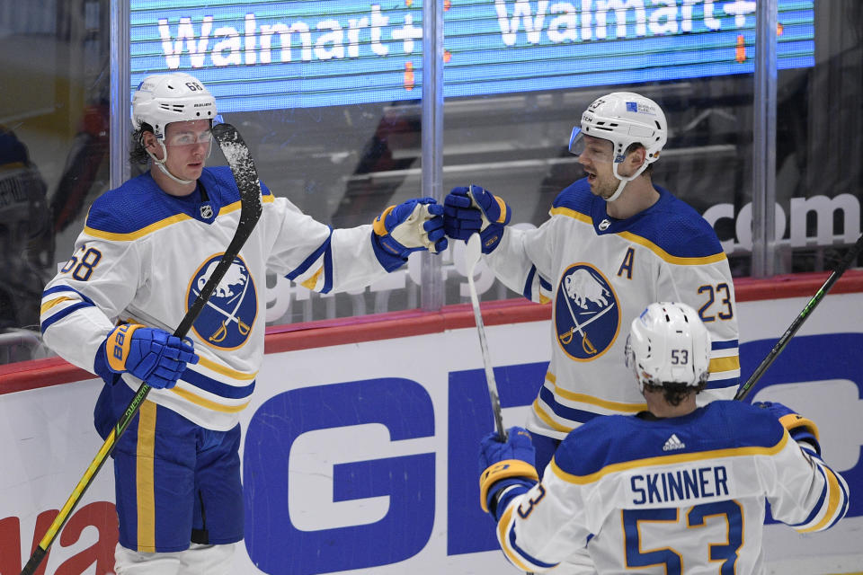 Buffalo Sabres left wing Victor Olofsson (68) celebrates his goal with right wing Sam Reinhart (23) and left wing Jeff Skinner (53) during the second period of the team's NHL hockey game against the Washington Capitals, Thursday, April 15, 2021, in Washington. (AP Photo/Nick Wass)