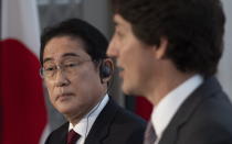 Japanese Prime Minister Fumio Kishida listens via a translation aid as Canadian Prime Minister Justin Trudeau responds to a question during a joint news conference, Thursday, Jan. 12, 2023 in Ottawa. (Adrian Wyld/The Canadian Press via AP)