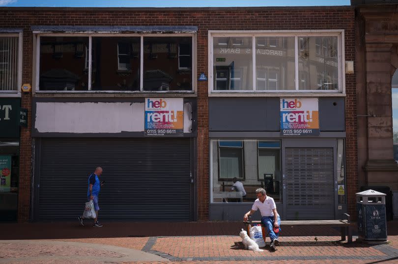 A man walks past two boarded up shops in Worksop town centre