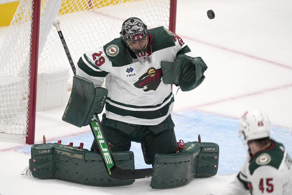 Minnesota Wild goaltender Marc-Andre Fleury (29) deflects a high shot to the net as defenseman Ryan O'Rourke (45) looks on in the first period of a preseason NHL hockey game, Tuesday, Sept. 26, 2023, in Dallas. (AP Photo/Tony Gutierrez)