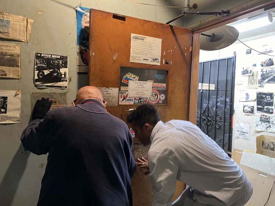 a group of men looking at a poster on the wall