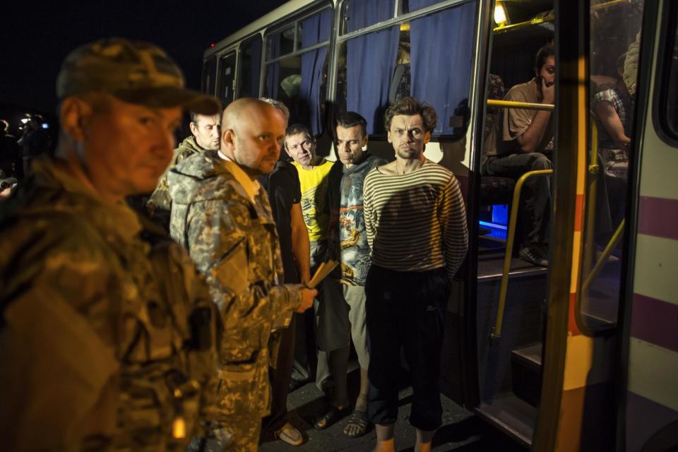 Members of the pro-Russian rebels, who are prisoners-of-war, stand in front of a bus they wait to be exchanged, north of Donetsk, eastern Ukraine