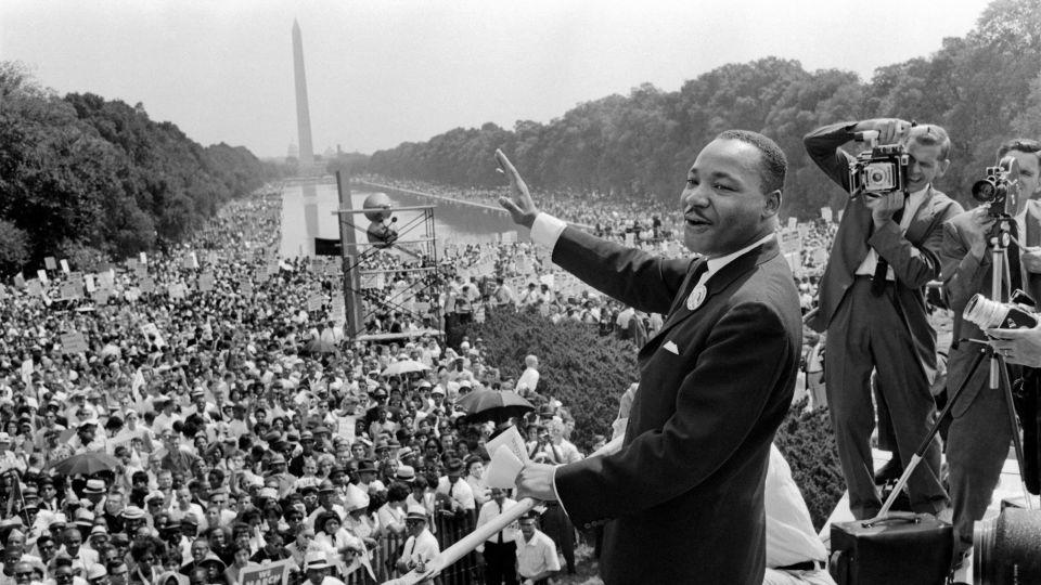 US civil rights leader Martin Luther King (C) waves to supporters 28 August 1963 on the Mall in Washington DC during the 