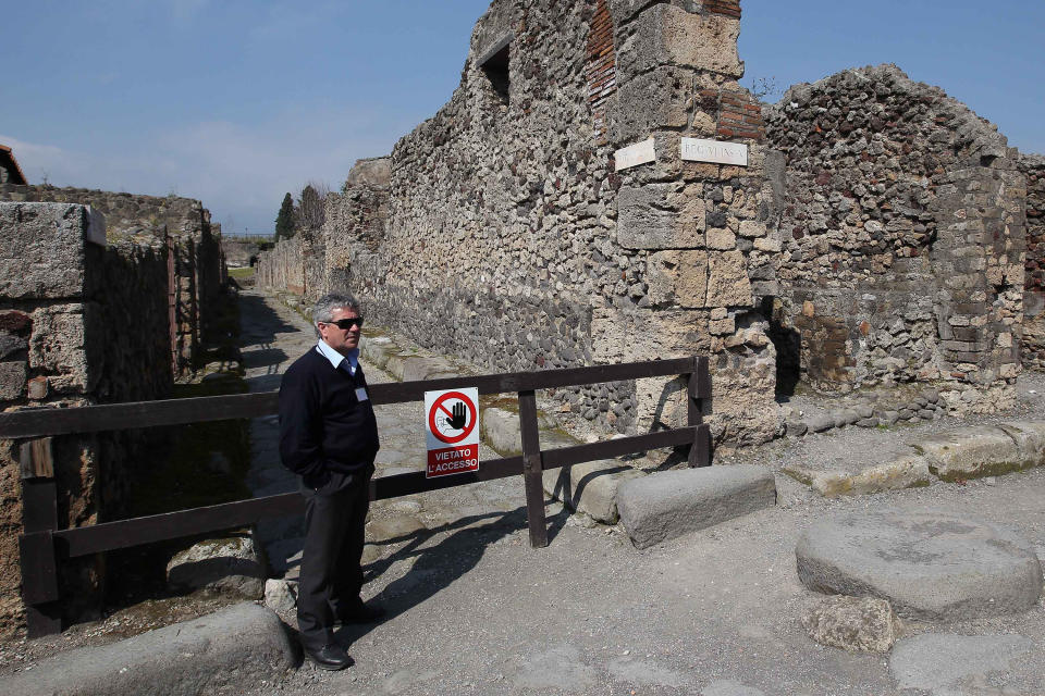 A man stands by the area where thieves pried off a chunk of an ancient fresco of the Greek goddess Artemis from the walls of Pompeii, Italy, Tuesday, March 18, 2014. Pompeii's archaeological authorities said Tuesday the theft occurred on March 12 in the "Home of Neptune," in an area of Pompeii's sprawling excavation site not currently open to the public. The thieves used a metal object to scrape off the upper corner of the fresco, making off with a faded, 20-centimeter image of Artemis, the Pompeii authorities said in a statement. It's the latest setback for the popular tourist site, which has seen several walls collapse in recent months due to heavy rains. Similar collapses in recent years have prompted an infusion of EU funds. (AP Photo/Marco Cantile, Lapresse)