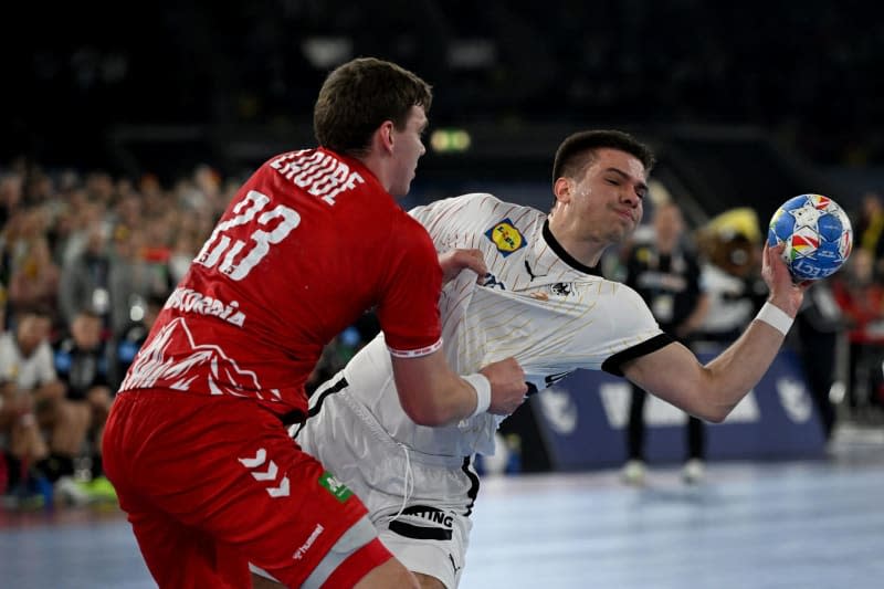 Germany's Renars Uscins (R) and Switzerland's Lukas Laube in action during the European Handball Championship Group A match between Germany and Switzerland  at the Merkur Spiel-Arena. Federico Gambarini/dpa