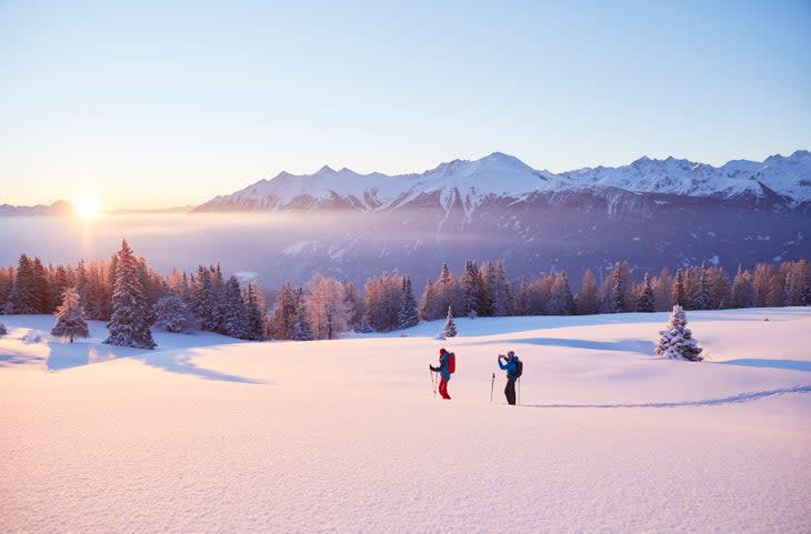 a couple hikes in the snow among mountains