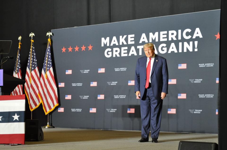 GOP presidential candidate Donald Trump stands on stage during a playing of Lee Greenwood’s “God Bless the USA” before his campaign speech in Ottumwa, Iowa.