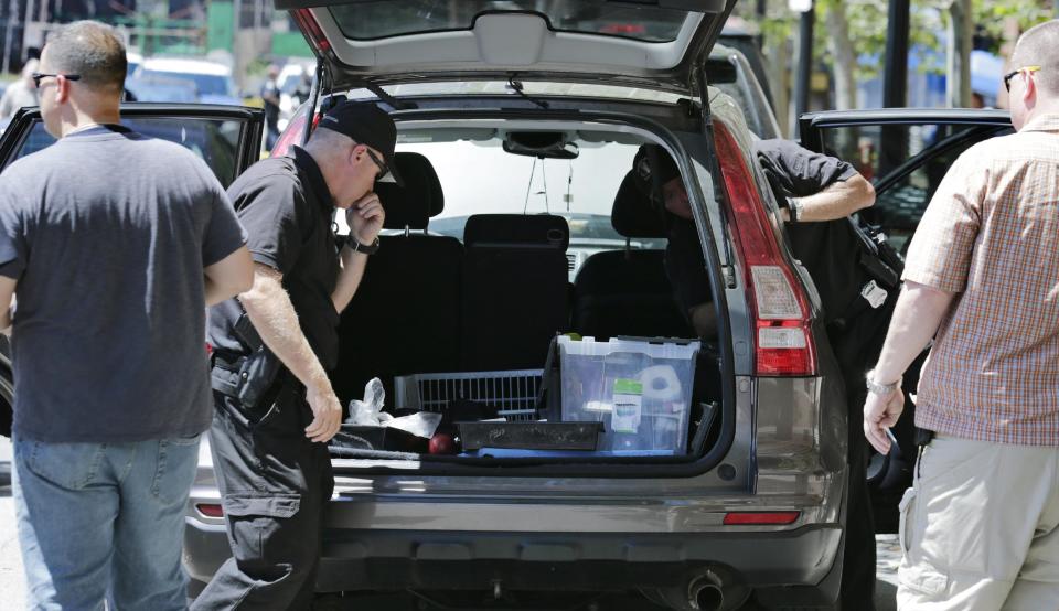 Bomb squad technicians search an SUV outside the federal courthouse in Boston. (Charles/AP)