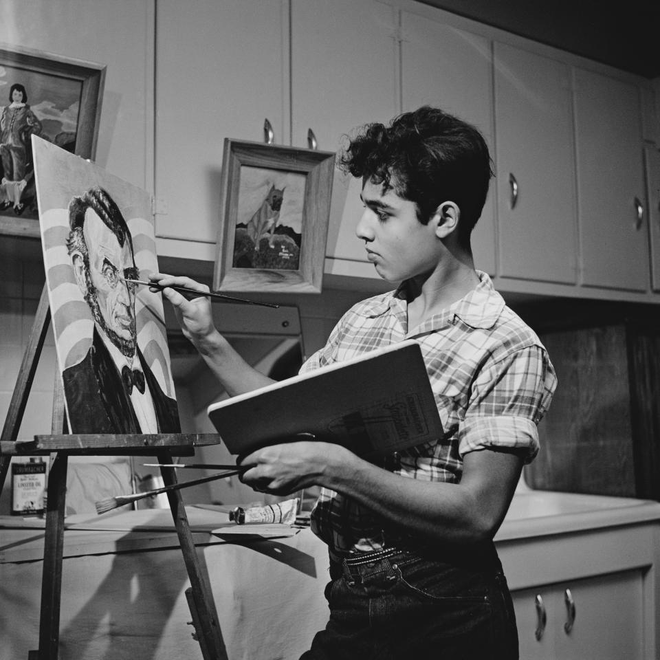 Bronx-born Mineo found his Hollywood breakthrough with his supporting role in the iconic James Dean drama <em>Rebel Without a Cause.</em> Pictured here is the actor painting in the kitchen of his family home in November 1955, the month after the now classic film’s release. The Mineos relocated to the New York town of Mamaroneck from the Bronx in 1956, after the young Oscar nominee <a href="https://www.nytimes.com/1976/02/18/archives/250-attend-sal-mineo-funeral-actor-is-called-gentle-person.html" rel="nofollow noopener" target="_blank" data-ylk="slk:bought;elm:context_link;itc:0;sec:content-canvas" class="link ">bought</a> a $200,000 residence following his early career success.
