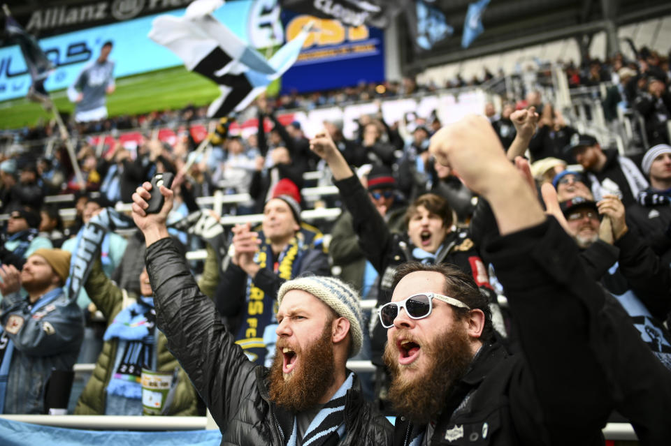 In this April 13, 2019, photo, Minnesota United supporters Eric Stevens, left, from Mississippi, and Dan Vitale, of Seattle, cheered as their team took the field for warmups before an MLS soccer match in St. Paul, Minn. The first season for Minnesota United at Allianz Field has been a sold-out success. As the Loons prepare for their first MLS playoff game, they'll have their raucous supporters section behind them to help. (Aaron Lavinsky/Star Tribune via AP)