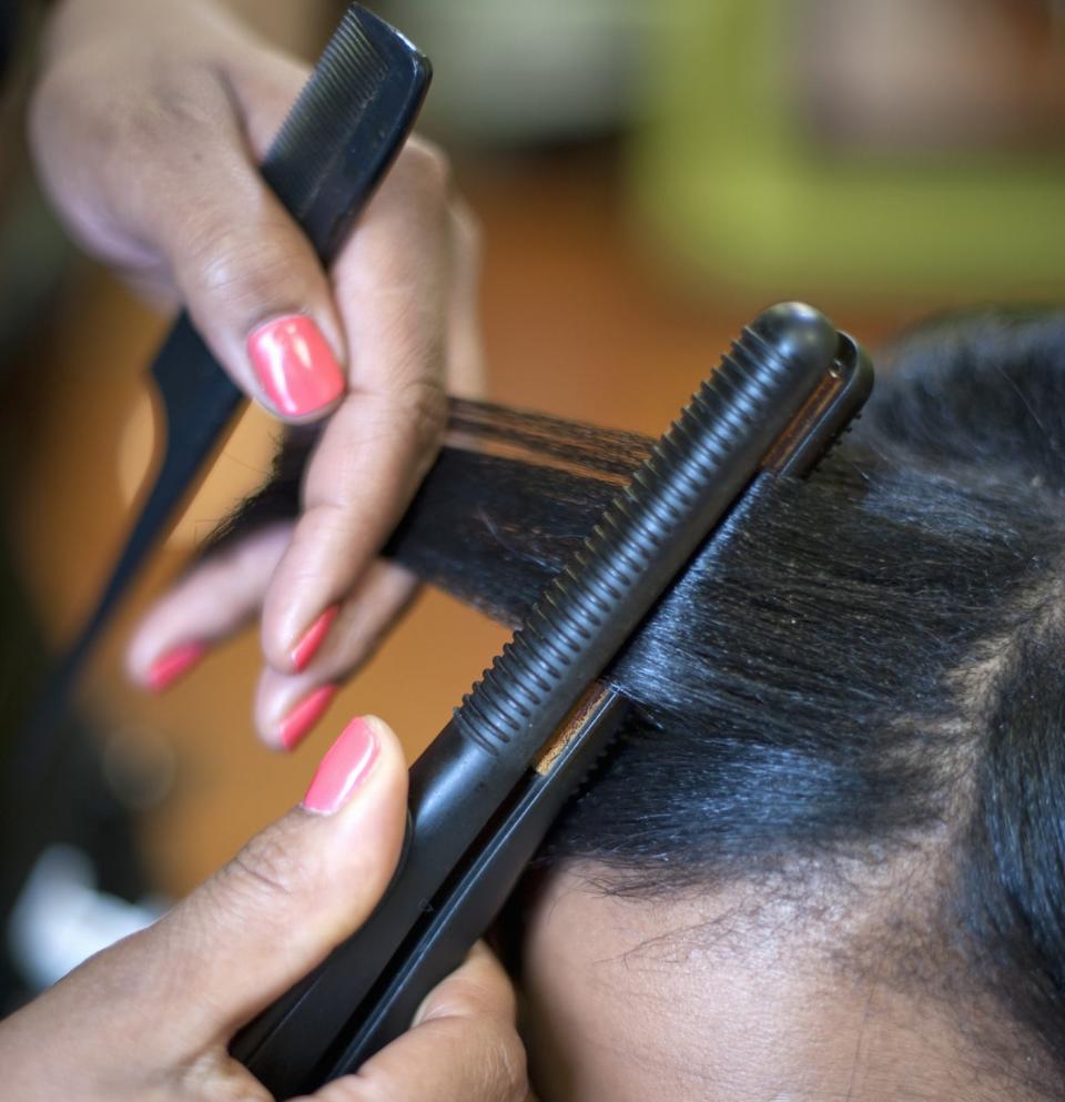 a flat iron being used on a hair