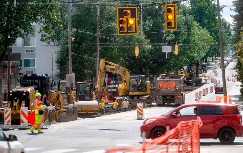 A flagger controls traffic at the intersection of Atherton Street and Beaver Avenue on Thursday, Aug. 17, 2023.