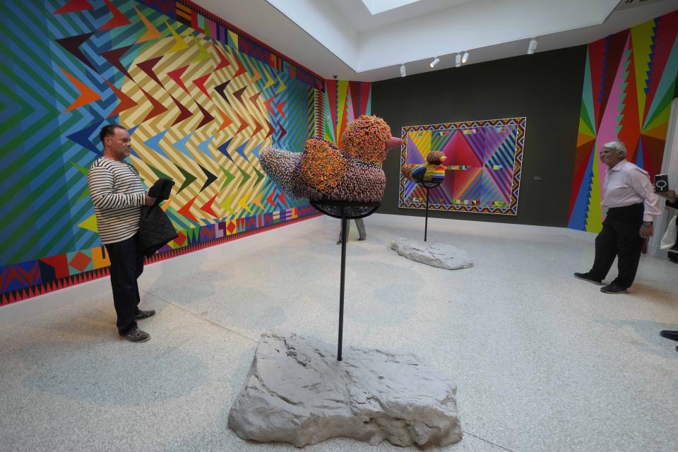 Visitantes miran esculturas del artista Jeffrey Gibson en el pabellón estadounidense en la 60a Bienal de Artes en Venecia, Italia, el martes 16 de abril de 2024. Gibson, un choctaw de Mississippi de ascendencia cherokee, es el primer indígena estadounidense en representar a Estados Unidos en solitario en la Bienal de Venecia, la muestra de arte contemporáneo más antigua del mundo. (Foto AP/Luca Bruno)