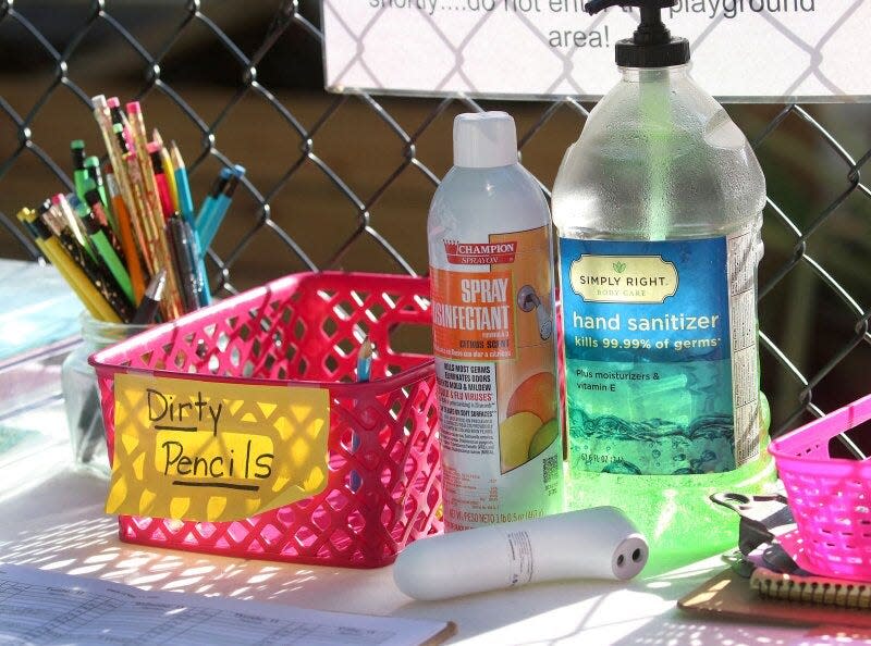 The check-in table at the Imagination Station child care center includes hand sanitizer, spray disinfectant, a contactless thermometer and a bin for used pencils. Child care centers across the country have adopted strict health protocols to prevent the spread of the coronavirus.