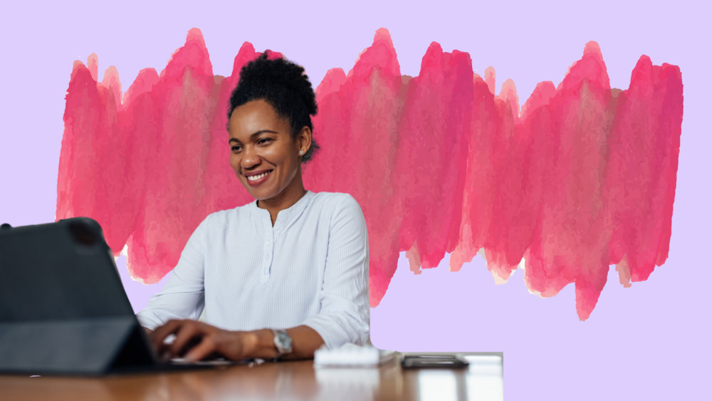 A woman sitting at her laptop in front of a painterly background.