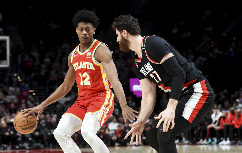 Atlanta Hawks forward De'Andre Hunter, left, looks to get past Portland Trail Blazers center Jusuf Nurkic, right, during the first half of an NBA basketball game in Portland, Ore., Monday, Jan. 30, 2023. (AP Photo/Steve Dykes)