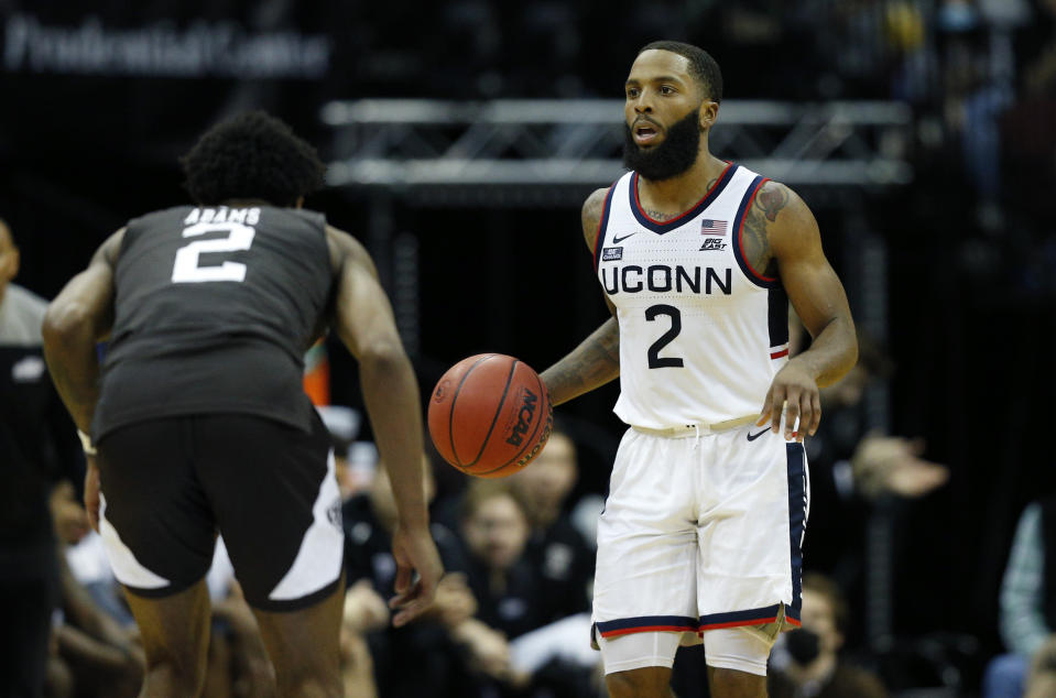 Connecticut guard R.J. Cole (2) dribbles the ball as St. Bonaventure guard Quadry Adams (2) defends during the second half of an NCAA college basketball game in Newark, N.J. Saturday, Dec. 11, 2021. (AP Photo/Noah K. Murray)