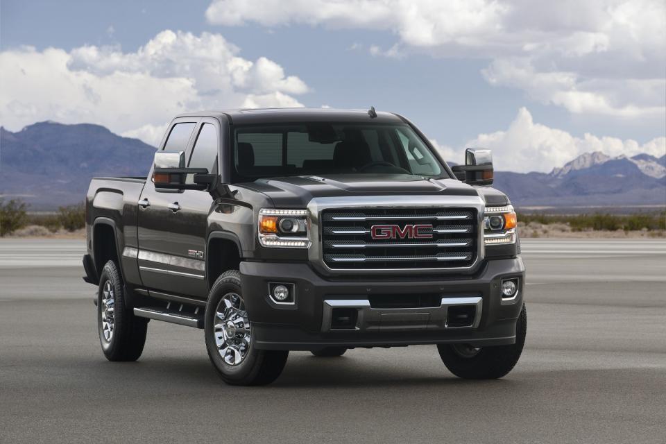 Truck on tarmac in front of a mountain range.