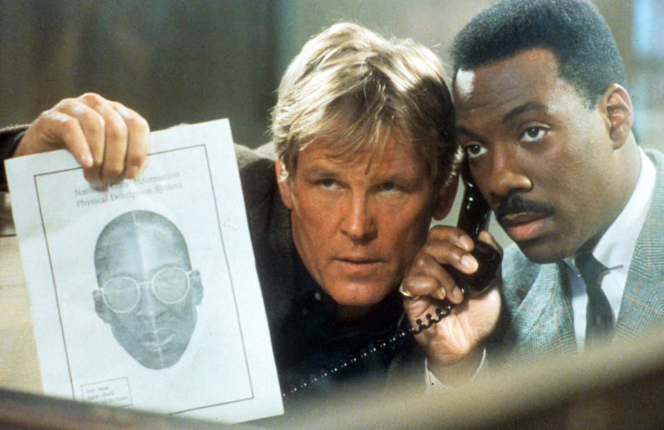 Nick Nolte and Eddie Murphy listening to phone while showing artist's depiction of suspect in scene from the film 'Another 48 Hrs.', 1990. (Photo by Paramount/Getty Images)
