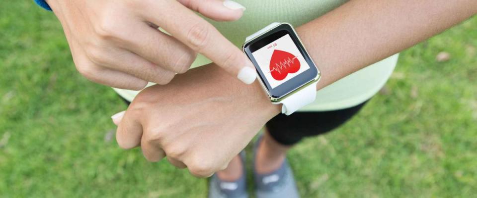 woman outside in sportswear looking at smartwatch