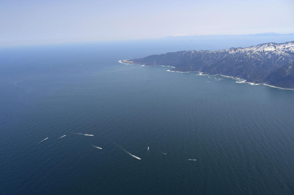 Rescuers conduct a search operation near Shiretoko Peninsula in northern Japan of Hokkaido Sunday, April 24, 2022. The Japanese Coast Guard said Sunday that rescue helicopters found nine of the 26 people from a tour boat missing in the frigid waters of northern Japan since the day before, but their conditions are unknown. (Kyodo News via AP)