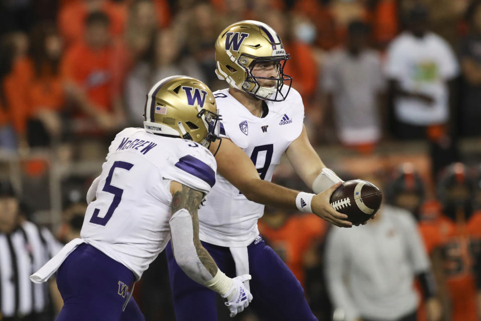 Washington quarterback Dylan Morris (9) hands off to running back Sean McGrew (5) during the first half of an NCAA college football game against Oregon State on Saturday, Oct. 2, 2021, in Corvallis, Ore. (AP Photo/Amanda Loman)