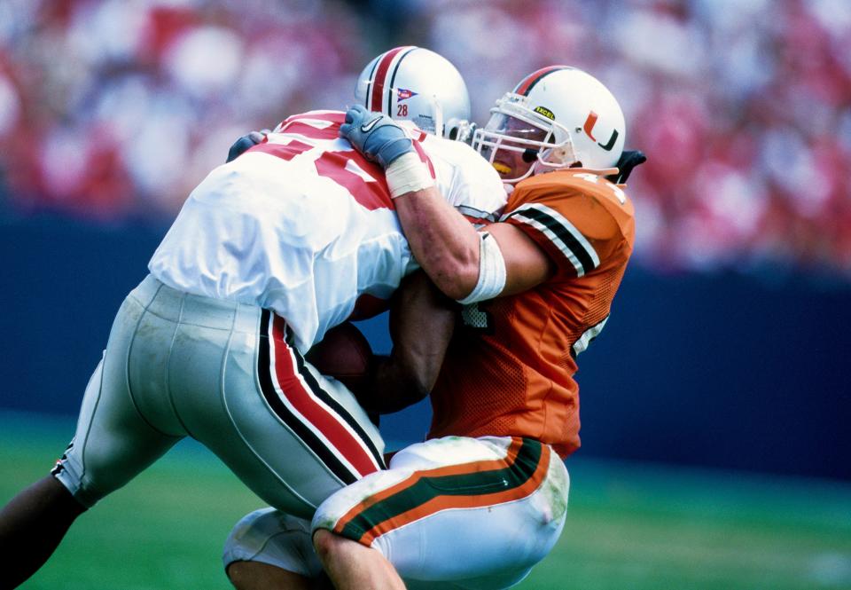 Aug 29, 1999; East Rutherford, NJ, USA; FILE PHOTO; Miami Hurricanes line backer Dan Morgan (44) attempts to tackle Ohio State Buckeyes running back Jonathan Wells (28) at Giants Stadium. Mandatory Credit: RVR Photos-USA TODAY Network