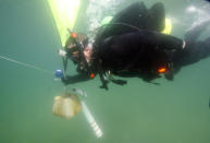 In this Saturday, Jan. 14, 2012 photo, Kenny Jenkins uses a lift bag to help him carry a weight and geocache marker to place it in about 33 ft. of water in Lake Denton in Avon Park Fla. Interest in geocaching has grown significantly over the years. But combining the two hobbies, geocaching and scuba diving, has only recently taken off. About 100 geocaches around the world today are only accessible with scuba gear, according to the geocaching.com database. (AP Photo/Wilfredo Lee)