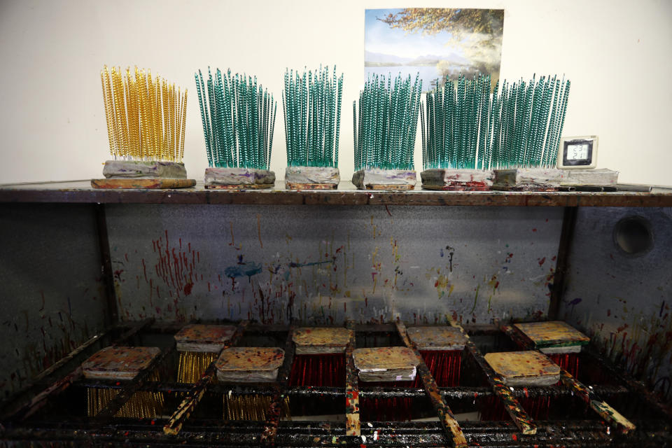 In this picture taken on Wednesday, Nov. 28, 2018, small blown glass beads are placed to dry during the manufacturing process to make traditional Christmas decorations in the village of Ponikla, Czech Republic. The small family business in a mountainous village in northern Czech Republic is the last place in the world where traditional Christmas decorations are made from glass beads blown and painted by hand. (AP Photo/Petr David Josek)