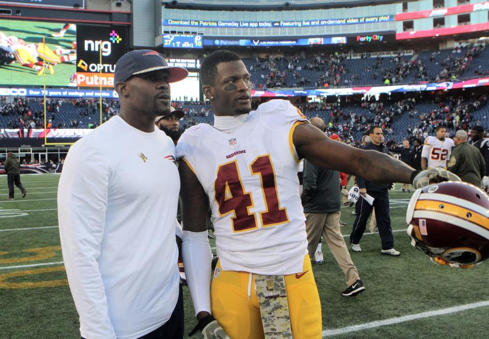 Patriots safeties coach Brian Flores talks with Redskins corner and former Bishop Hendricken player Will Blackmon after the game on the field at Gillette Stadium.The Providence Journal/Mary Murphy